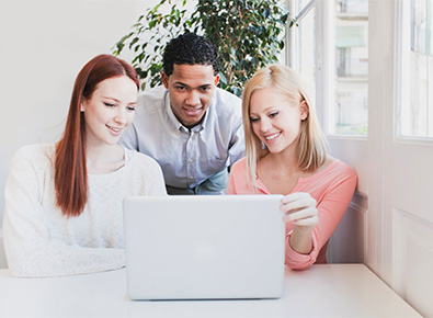 three people looking at a computer screen